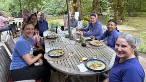 happy women eating dinner at outdoor yoga retreat in Oregon