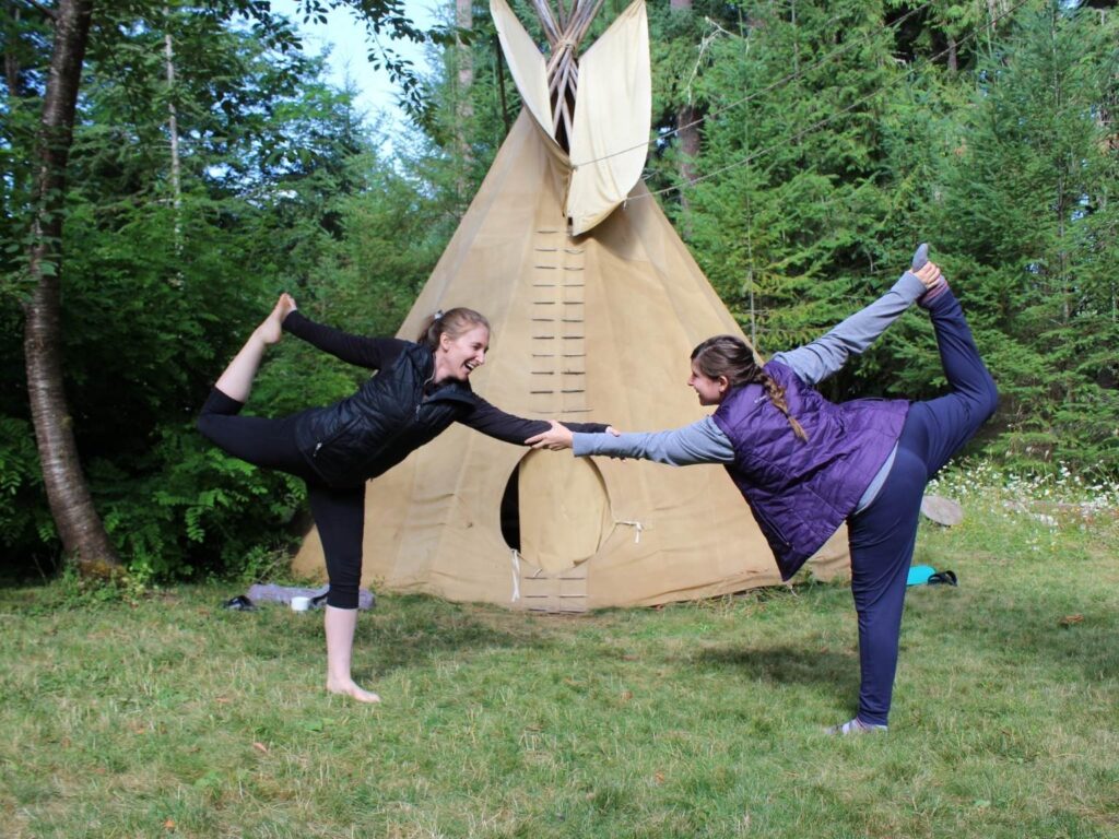 women practicing yoga in front of tipi at Oregon yoga retreat for women