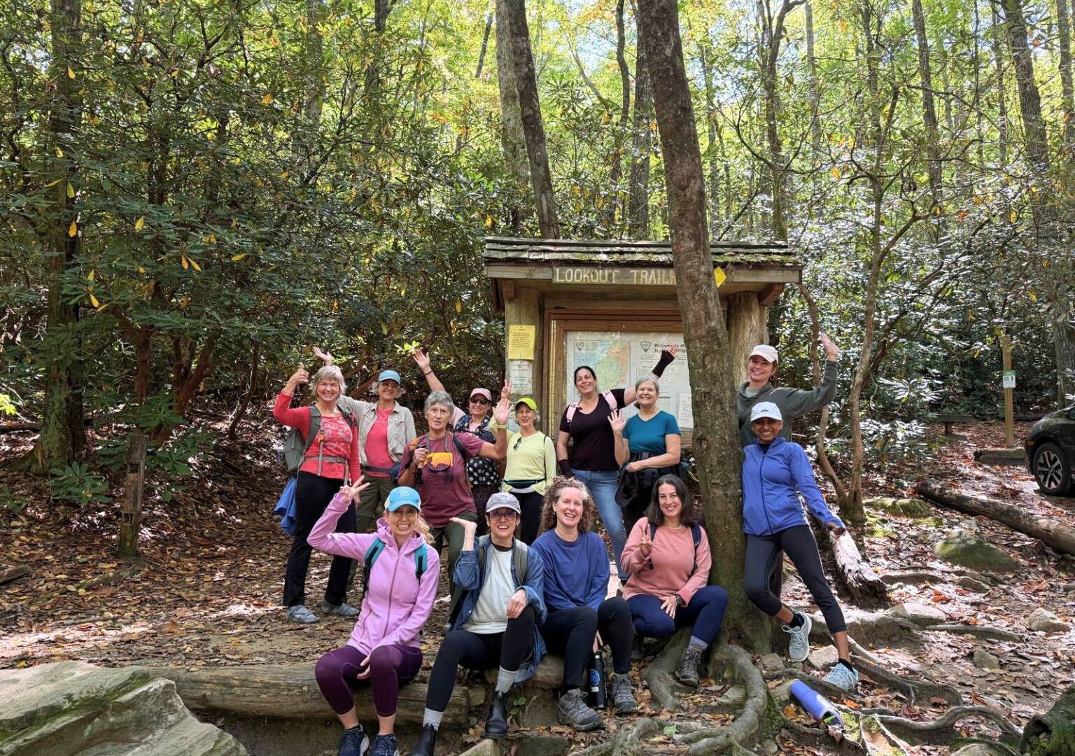 laughing women at trailhead during women's yoga retreat near asheville