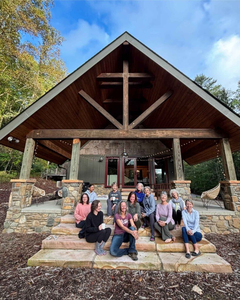 group of women in front of cabin at a yoga retreat only for women near Asheville