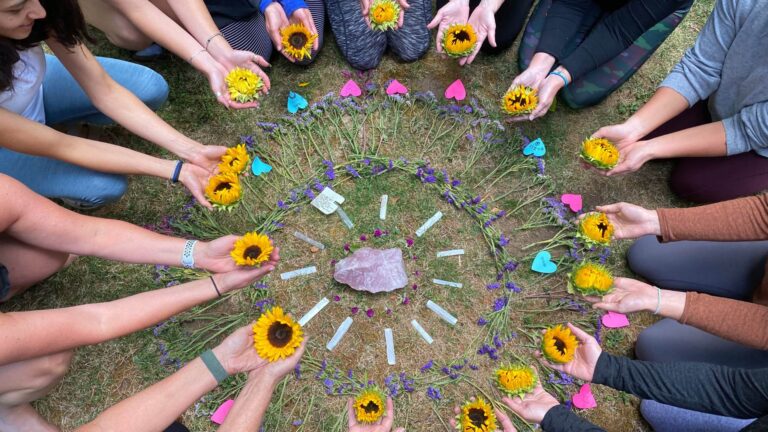 circle of hands and sunflowers during women's yoga retreat in Oregon