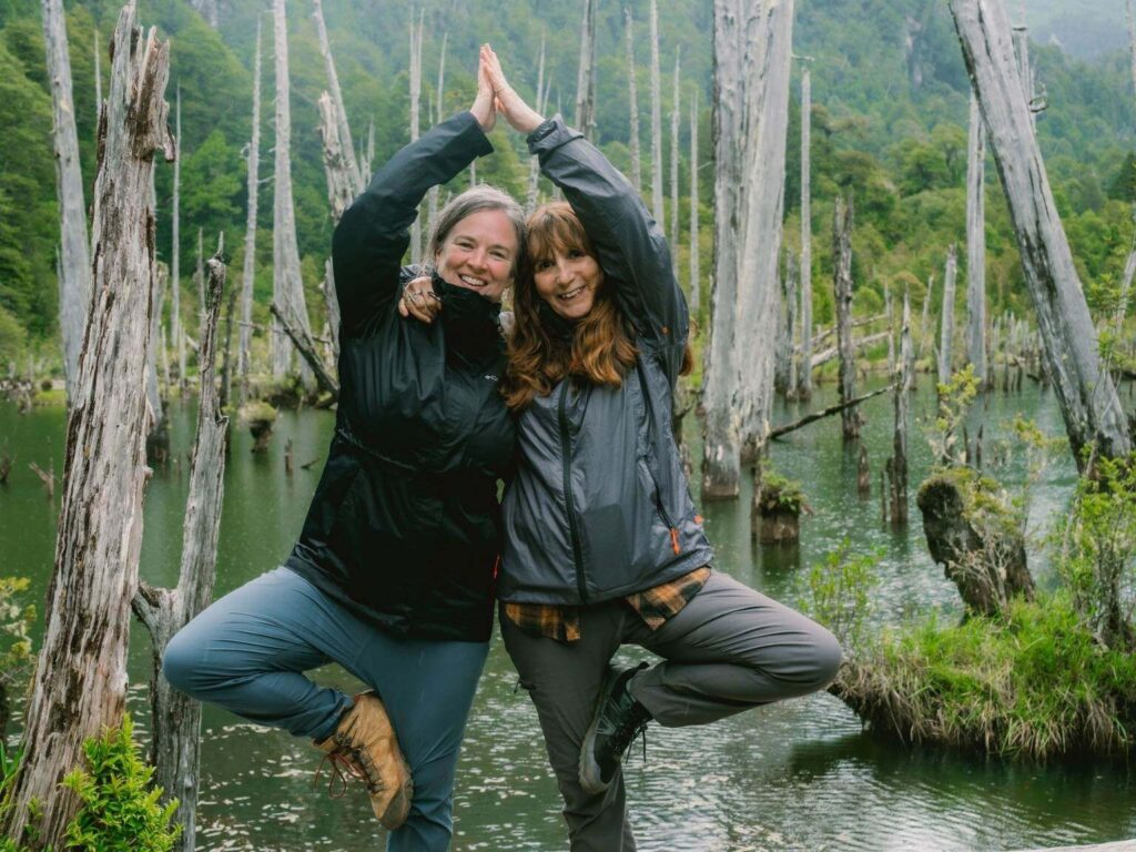 two women practicing tree pose at a yoga retreat in Chile
