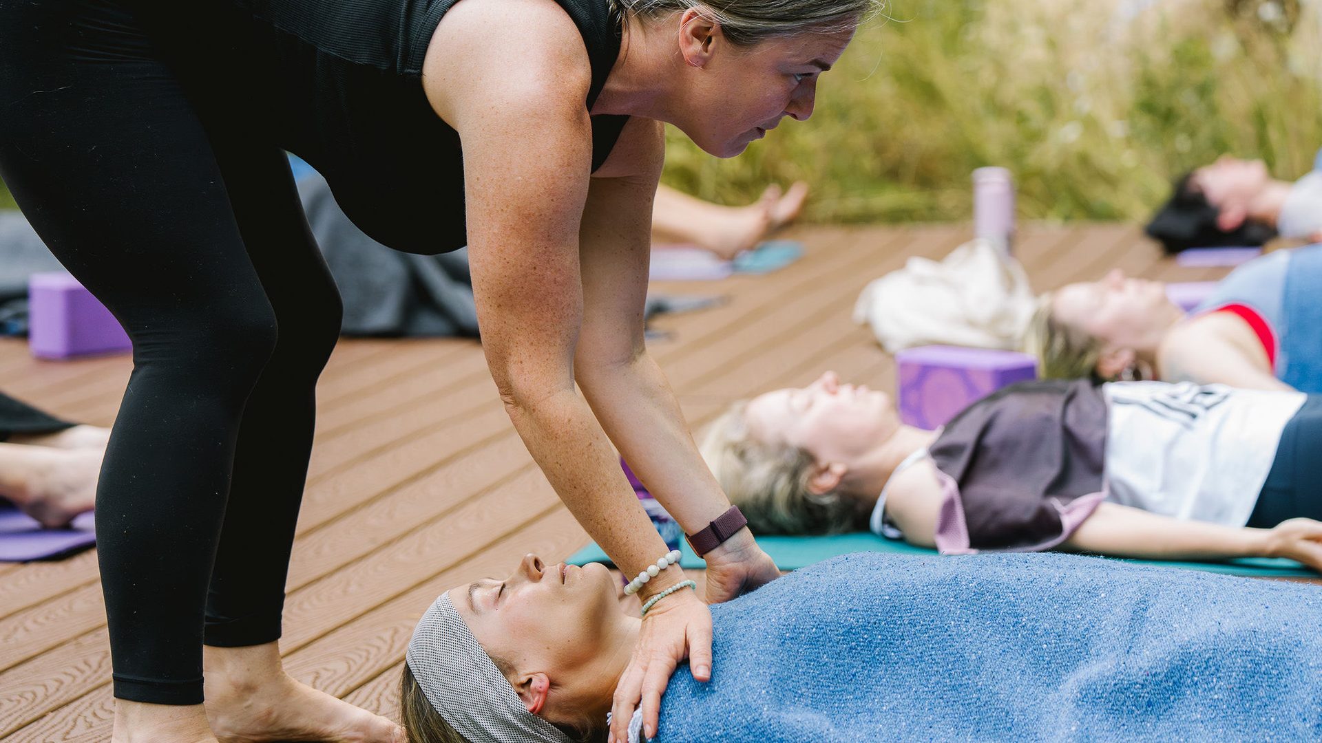 autumn adams preparing a student for shavasana and yoga nidra during an outdoor women's yoga retreat