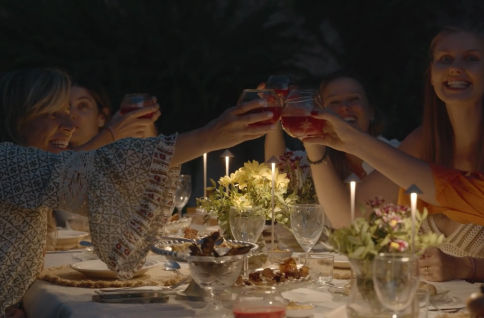 women enjoying a long dinner with a celebratory toast during a women's yoga retreat in Mallorca