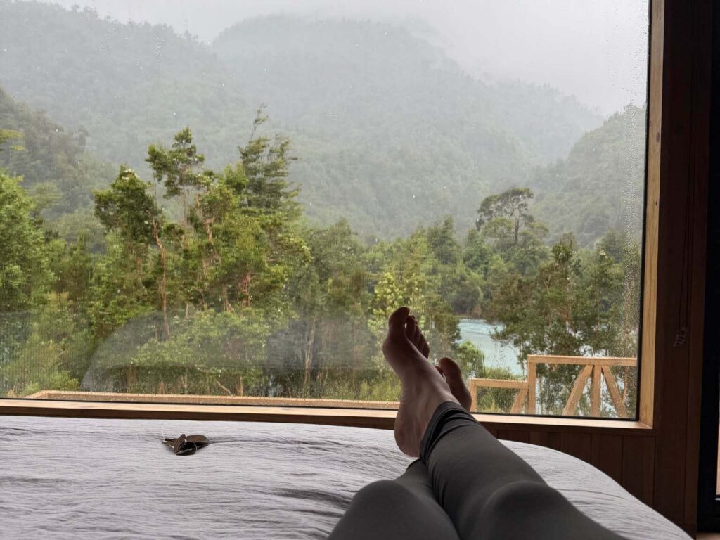 relaxing in bed with a book and tea during April Patagonia rainstorm during a retreat